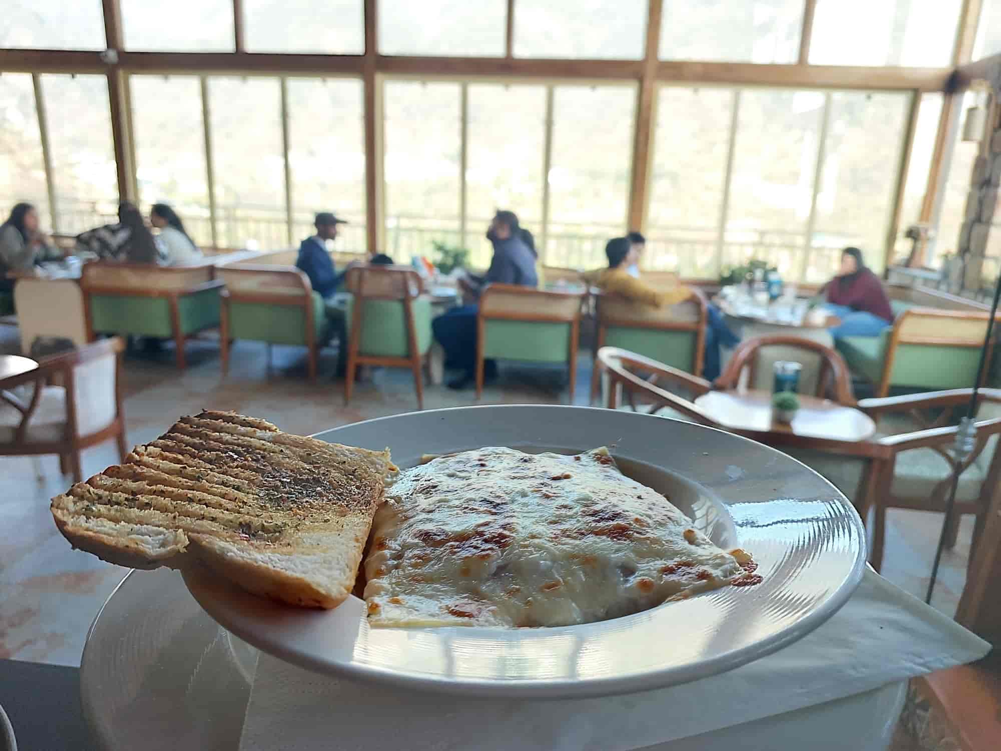 Food in foreground with full mountain view dining room at Narcoz